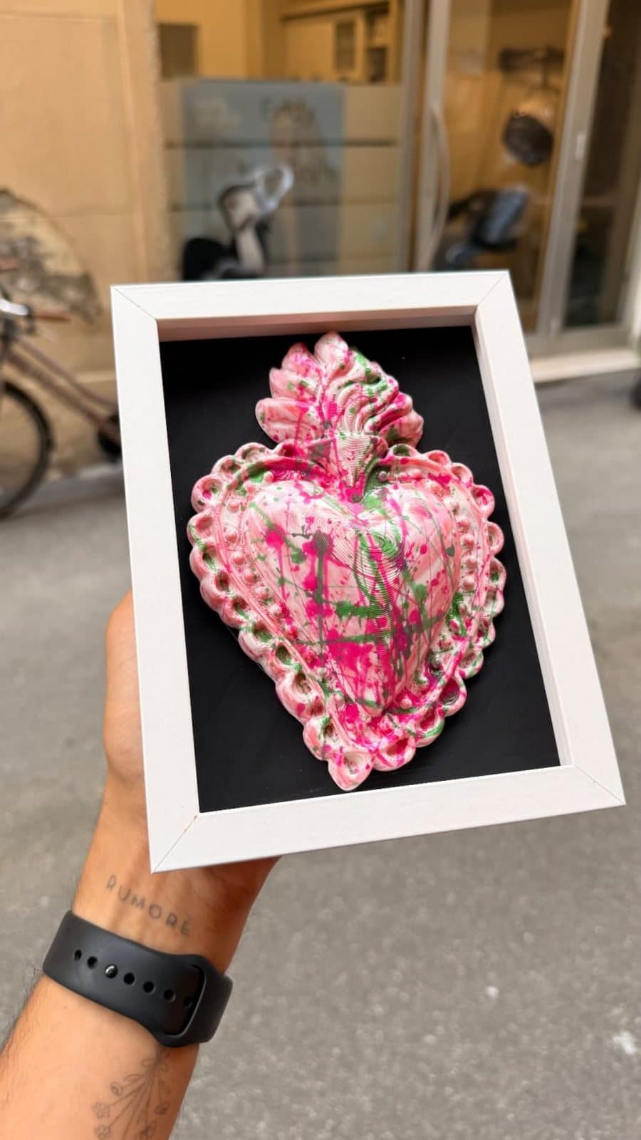 Sacro cuore ex-voto rosa in cornice bianca, tenuto in mano