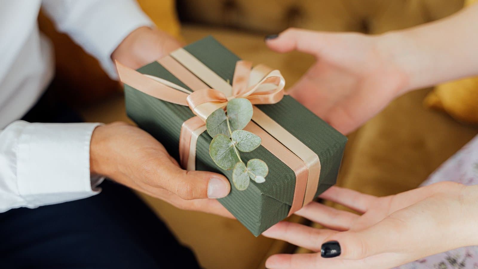 Two people, one handing over a wrapped gift