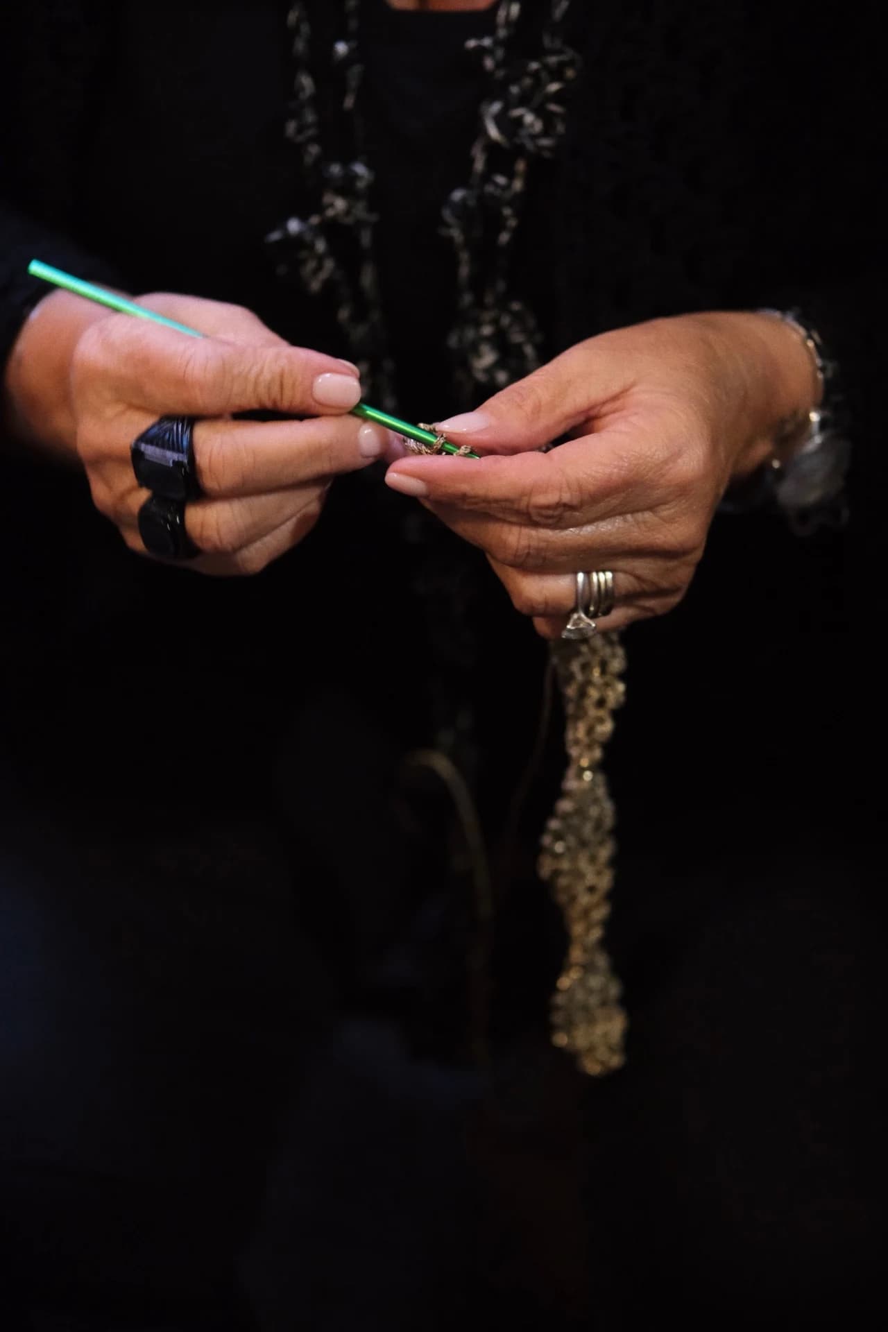 The hands of an exhibitor assembling a necklace during Comunella Market in Bologna